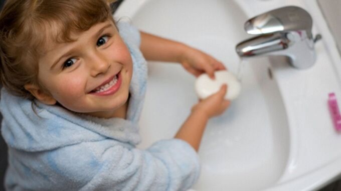 l'enfant se lave les mains avec du savon pour éviter les vers